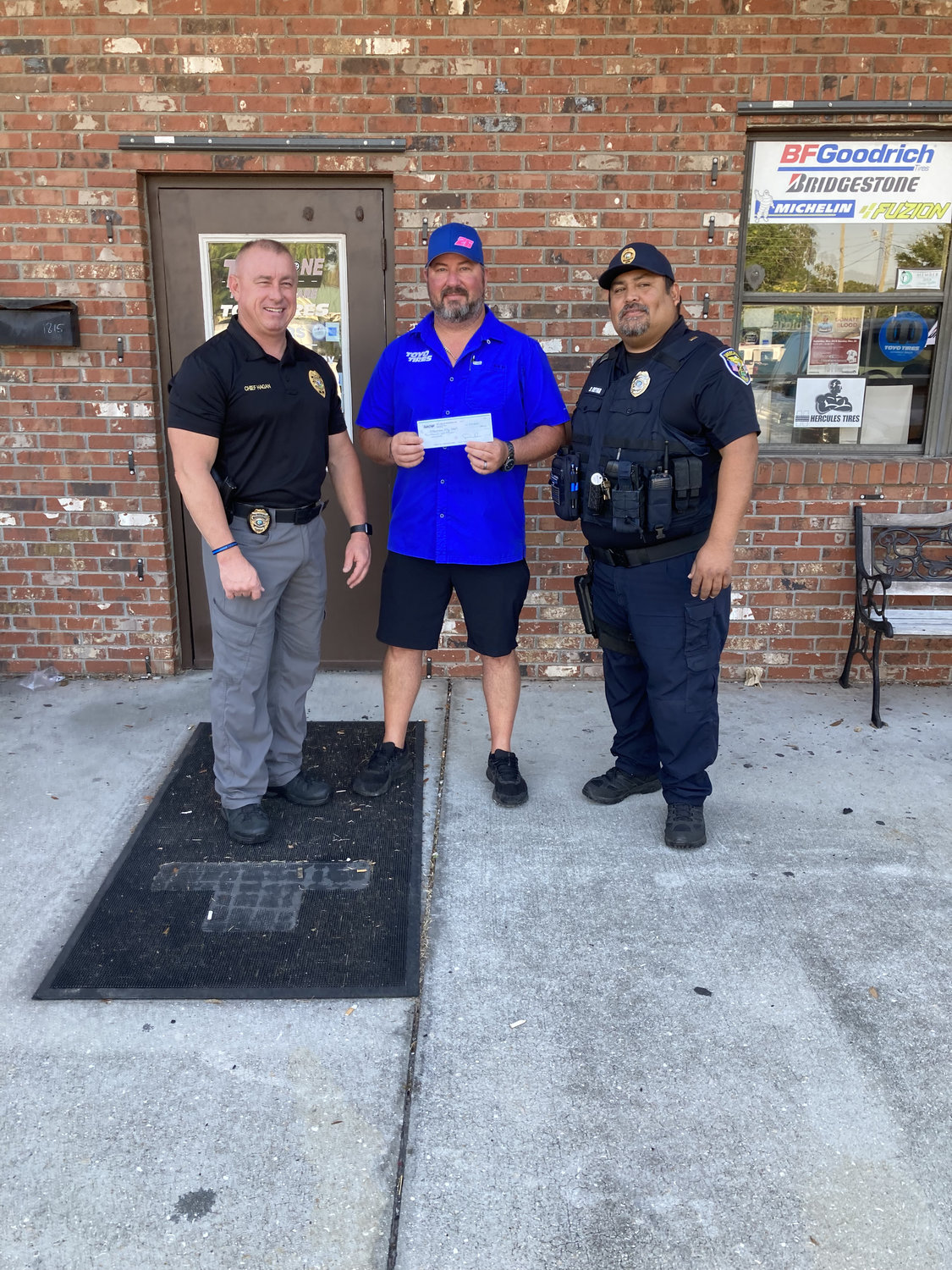 David McCormick from Tire Zone (center) presents check to Okeechobee City Police Chief Donald Hagan (right ) and Lt. B. Reyna to help with cost of training.